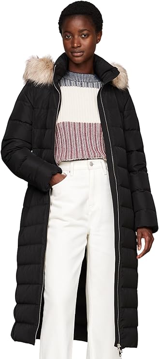 Der Tommy Hilfiger Damen Daunenmantel Heritage Tyra Maxi mit Fur und Kapuze ist das ideale Kleidungsstück für modebewusste Frauen, die sowohl Stil als auch Funktionalität schätzen. Mit einem Materialmix aus 100% recyceltem Polyester kombiniert dieser Mantel umweltfreundliche Praktiken mit einem zeitlosen Design. Die chemische Reinigung sorgt dafür, dass das Kleidungsstück seine Form und Farbe behält, während es gleichzeitig pflegeleicht bleibt.

Das ikonische Design des Mantels ist sowohl klassisch als auch modern. Der Reißverschluss und der Stehkragen bieten zusätzlichen Schutz gegen kalte Winde, während das Tommy Hilfiger Branding auf der Brust einen Hauch von Luxus und Markenbewusstsein vermittelt. Dieser Mantel ist nicht nur ein modisches Statement, sondern auch ein funktionales Kleidungsstück, das bei jedem Wetter getragen werden kann.

Die figurbetonte Passform sorgt dafür, dass der Mantel bequem sitzt und eine optimale Bewegungsfreiheit bietet, ohne dabei an Stil zu verlieren. Das Innenfutter aus Daunen hält Sie auch an den kältesten Tagen warm und gemütlich. Der Heritage Tyra Maxi Mantel ist somit der perfekte Begleiter für kalte Winter- und Herbsttage, egal ob im Alltag, bei einem Stadtbummel oder auf Reisen.

Die elegante Pufferjacke ist vielseitig einsetzbar und lässt sich problemlos mit verschiedenen Outfits kombinieren. Ob zu Jeans, Kleidern oder Röcken – dieser Mantel wertet jedes Outfit auf und sorgt dafür, dass Sie stets gut gekleidet sind.

Zusammengefasst ist der Tommy Hilfiger Damen Daunenmantel Heritage Tyra Maxi mit Fur und Kapuze eine ausgezeichnete Wahl für Frauen, die Wert auf Qualität, Stil und Komfort legen. Er vereint funktionale Eigenschaften mit einem ansprechenden Design und ist somit ein Muss für jede Wintergarderobe.